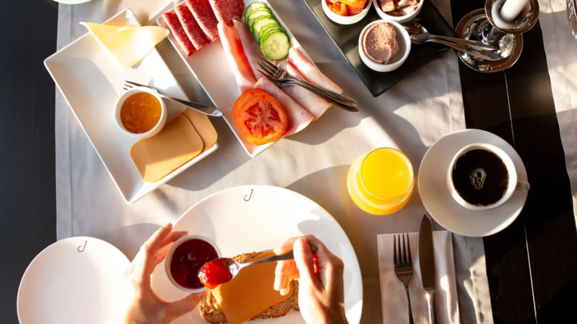 Frokostbord med pålegg, juice og kaffe sett ovenfra